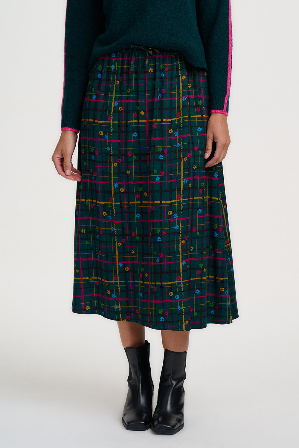 Person wearing a plaid skirt with colorful patterns on a white background