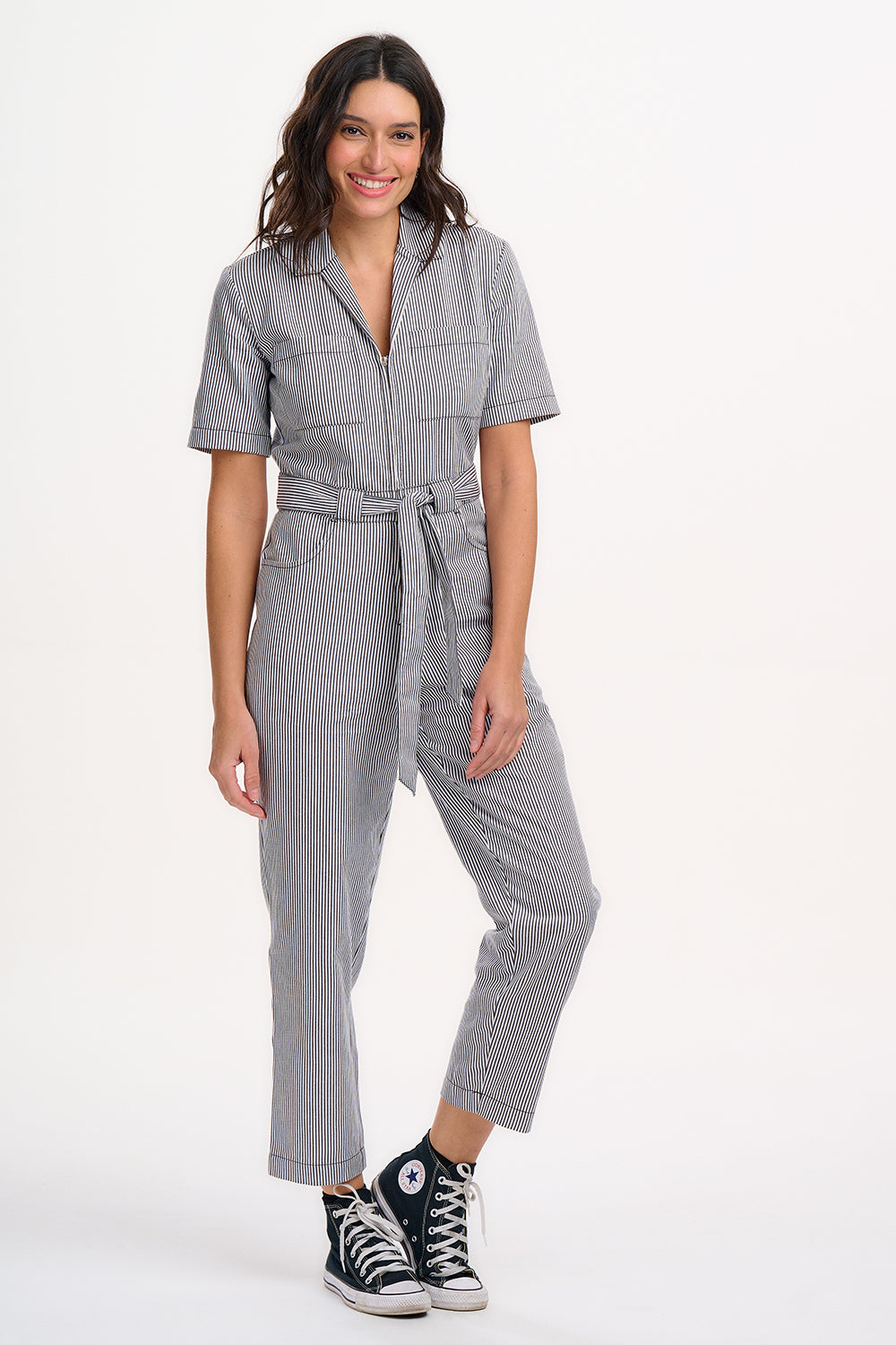 A person wearing a monochrome striped boilersuit with a round neckline and short sleeves