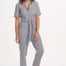 A person wearing a monochrome striped boilersuit with a round neckline and short sleeves