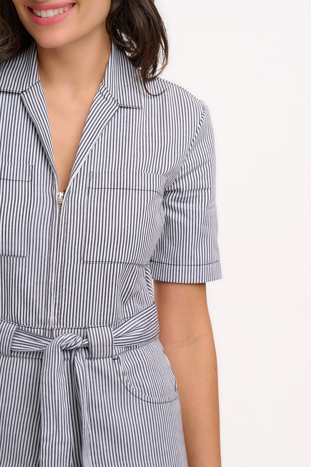A person wearing a monochrome striped boilersuit with a round neckline and short sleeves