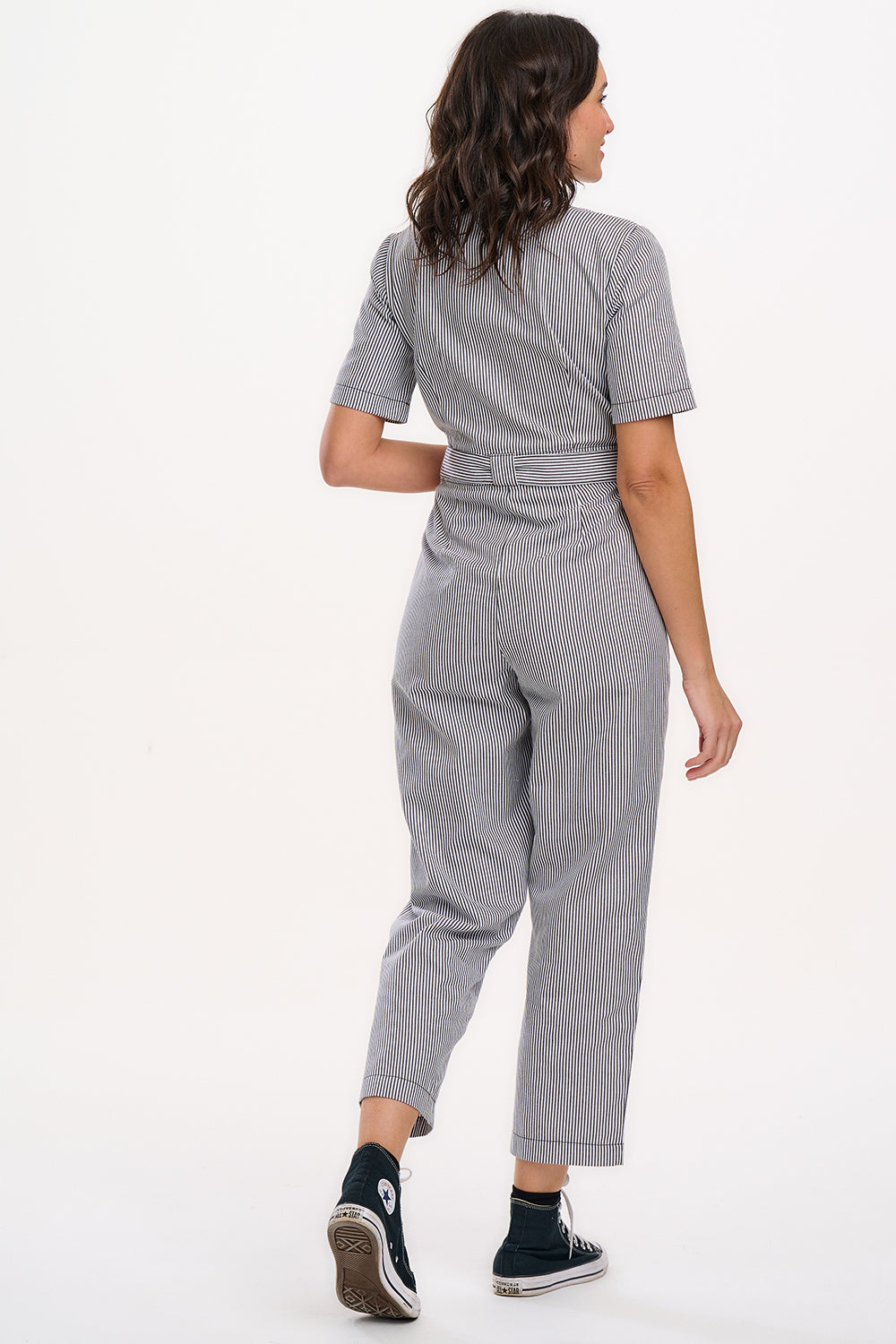 A person wearing a monochrome striped boilersuit with a round neckline and short sleeves