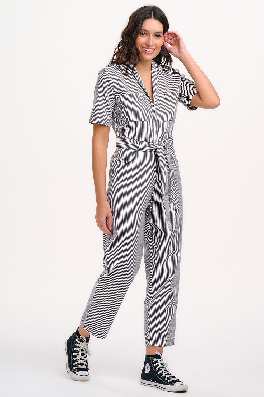 A person wearing a monochrome striped boilersuit with a round neckline and short sleeves