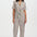 Woman wearing a colorful striped jumpsuit on a white background