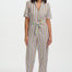 Woman wearing a colorful striped jumpsuit on a white background