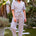 Woman wearing a colorful striped jumpsuit on a white background