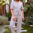 Woman wearing a colorful striped jumpsuit on a white background
