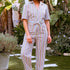 Woman wearing a colorful striped jumpsuit on a white background