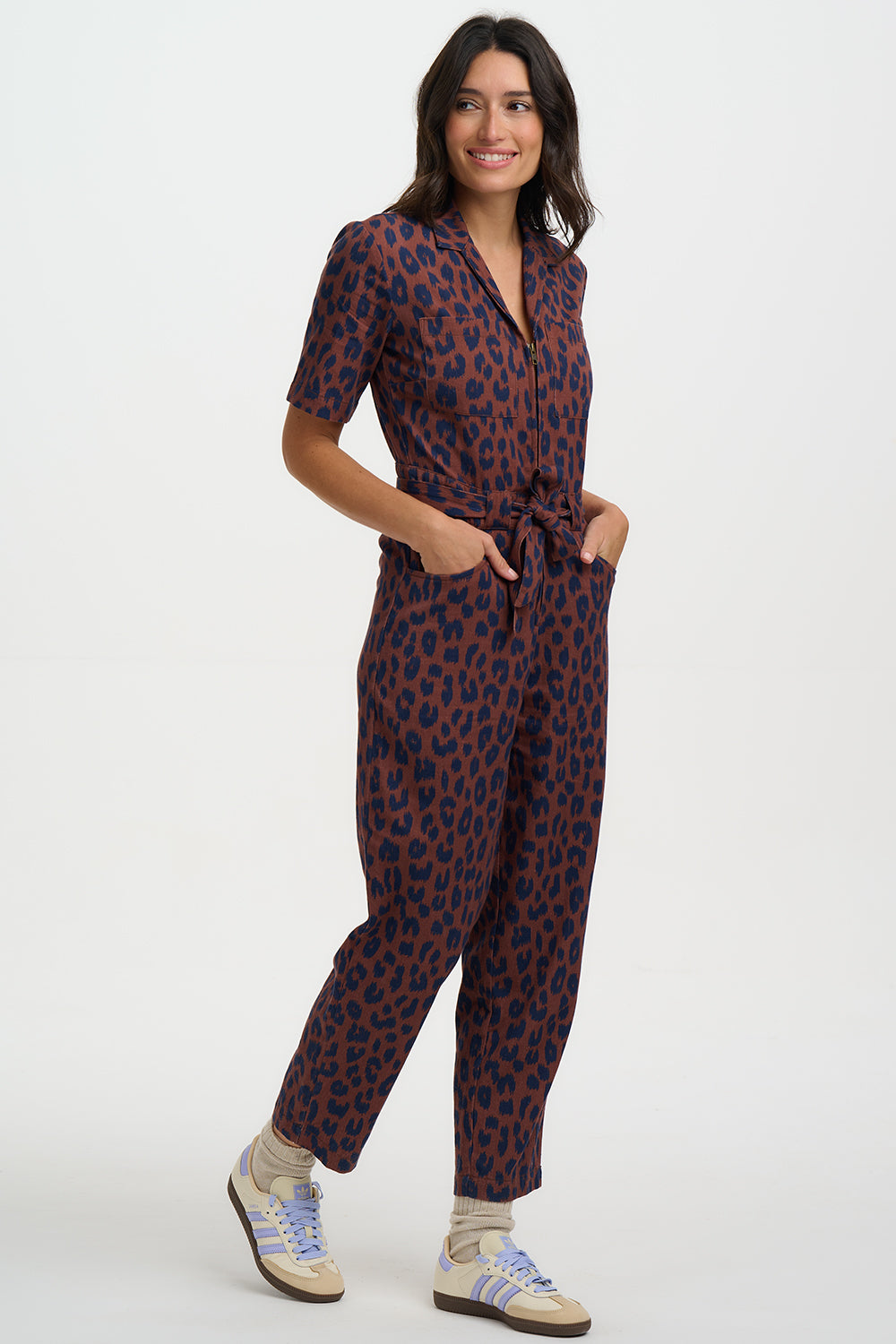Woman wearing a patterned jumpsuit on a white background