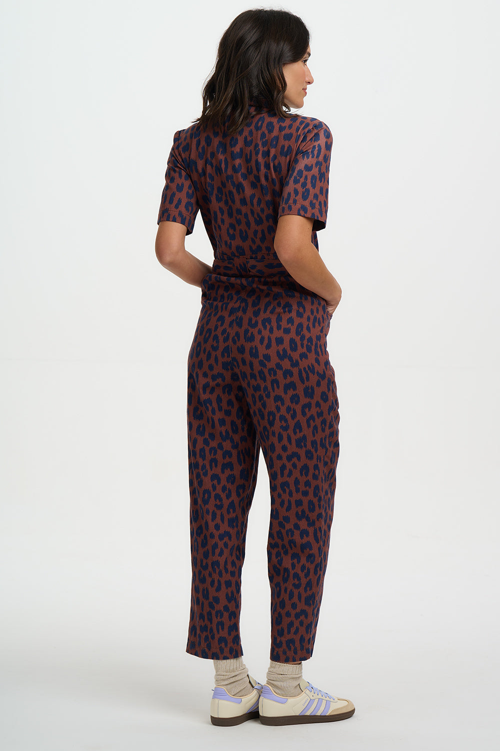 Person wearing a patterned jumpsuit on a white background