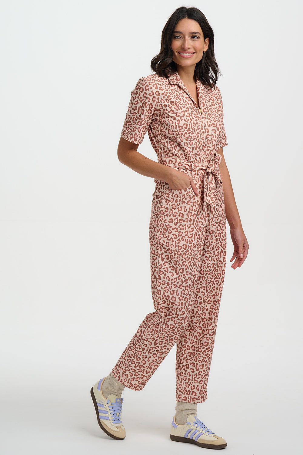 Woman wearing a pink leopard print jumpsuit on a white background