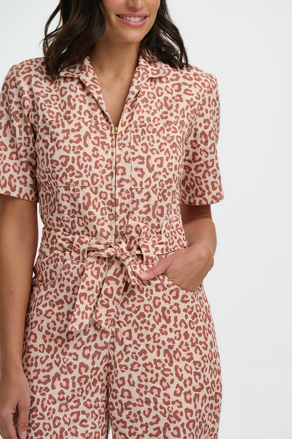 Woman wearing a leopard print jumpsuit on a white background