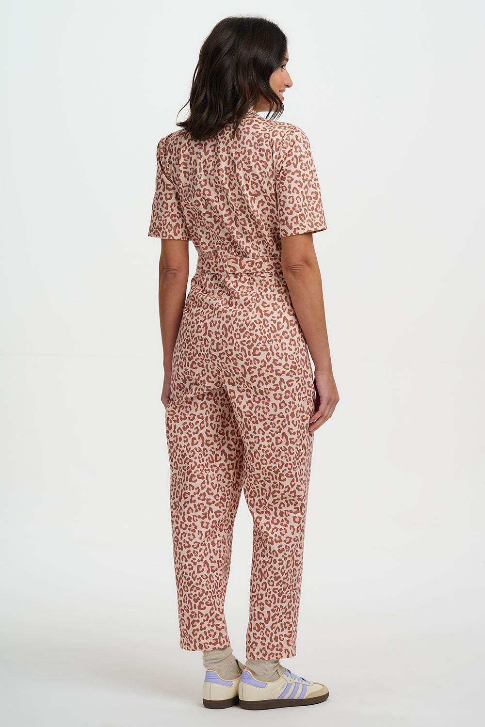 Woman wearing a patterned jumpsuit on a white background