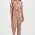 Woman wearing a patterned jumpsuit on a white background