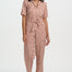 Woman wearing a patterned jumpsuit on a white background