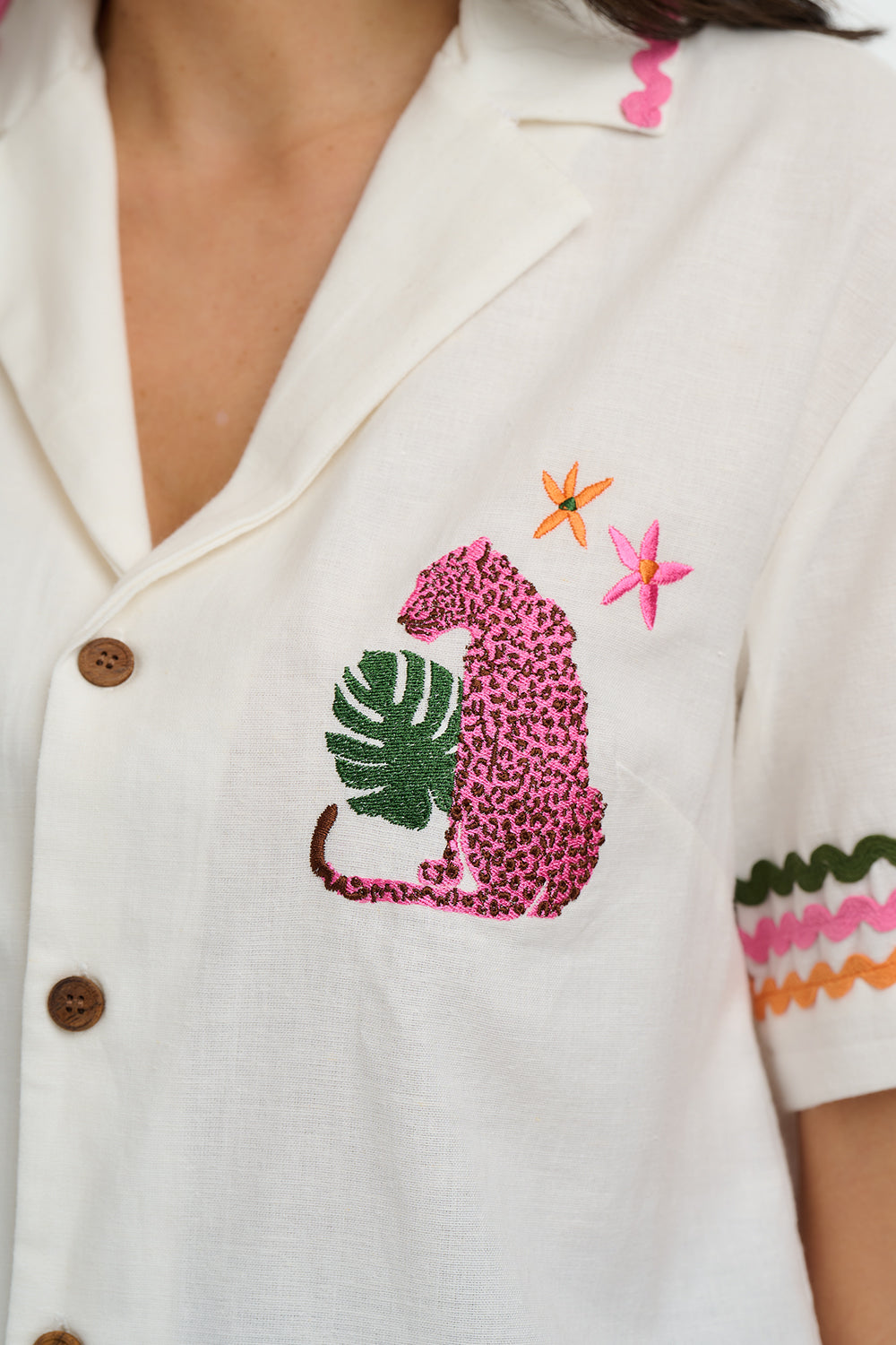 White blouse with pink leopard and green leaf embroidery