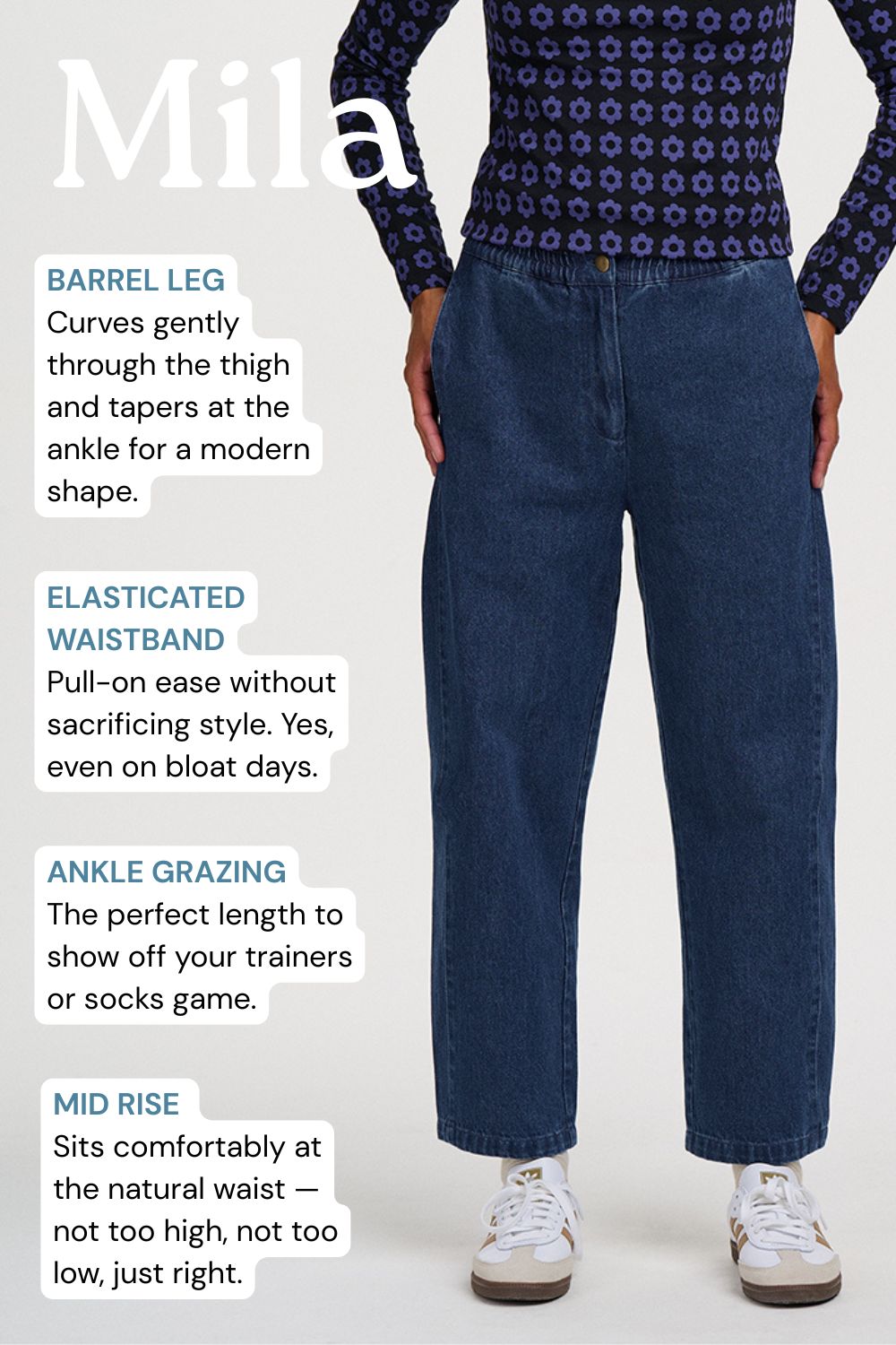 A model wearing dark blue denim jeans with a barrel leg and elasticated waistband, styled with a patterned navy top and white sneakers. The image features text callouts describing the jeans' features: barrel leg, elasticated waistband, ankle grazing, and mid rise.
