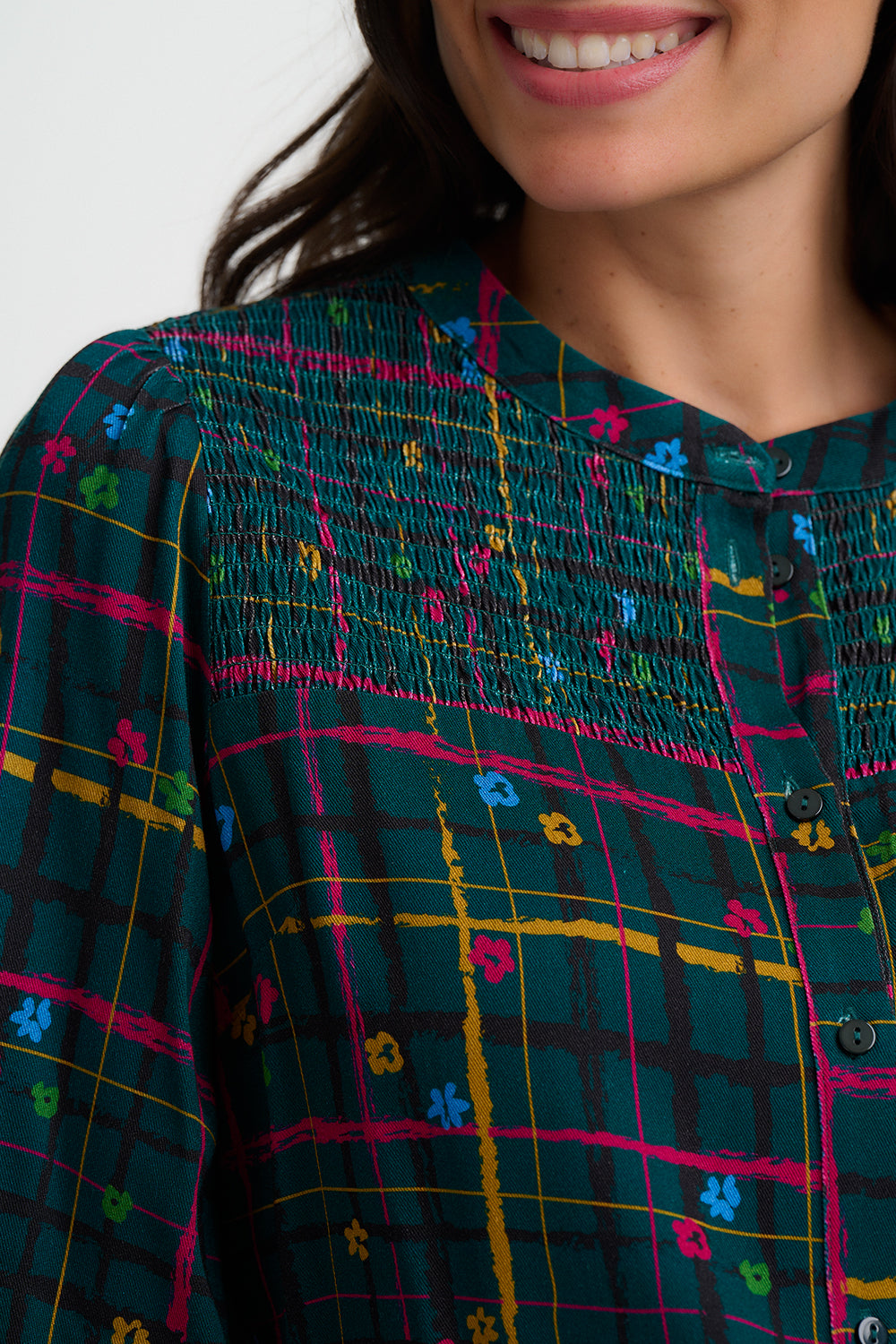 Close-up of a person wearing a colorful patterned shirt with a blurred background