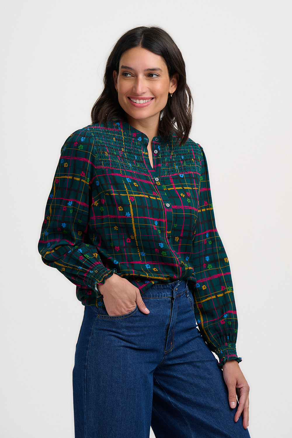 Woman wearing a plaid shirt and blue jeans on a white background