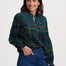 Woman wearing a plaid shirt and blue jeans on a white background