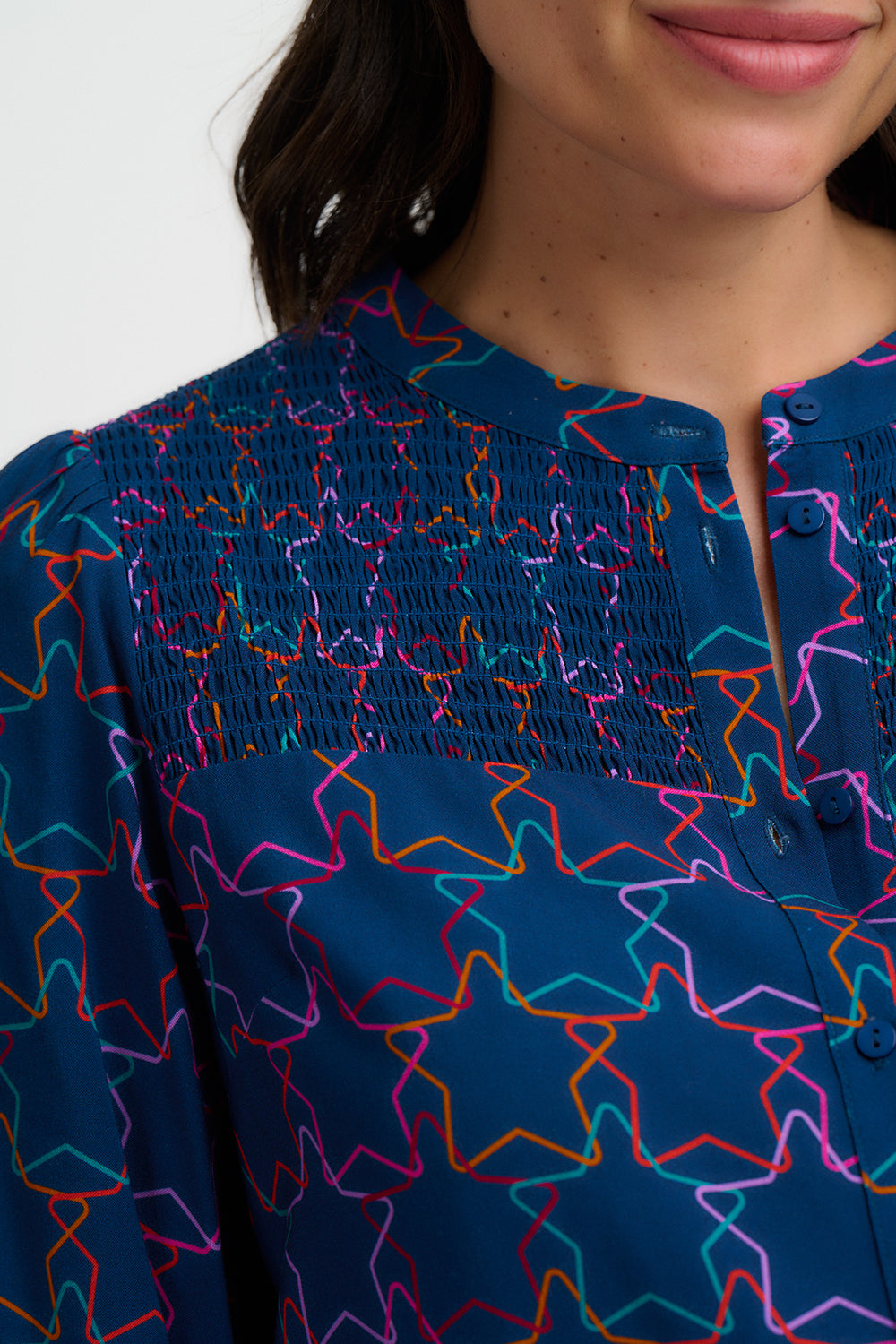 Close-up of a blue garment with colorful star patterns on a white background