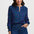 Woman wearing a blue patterned blouse and jeans on a white background