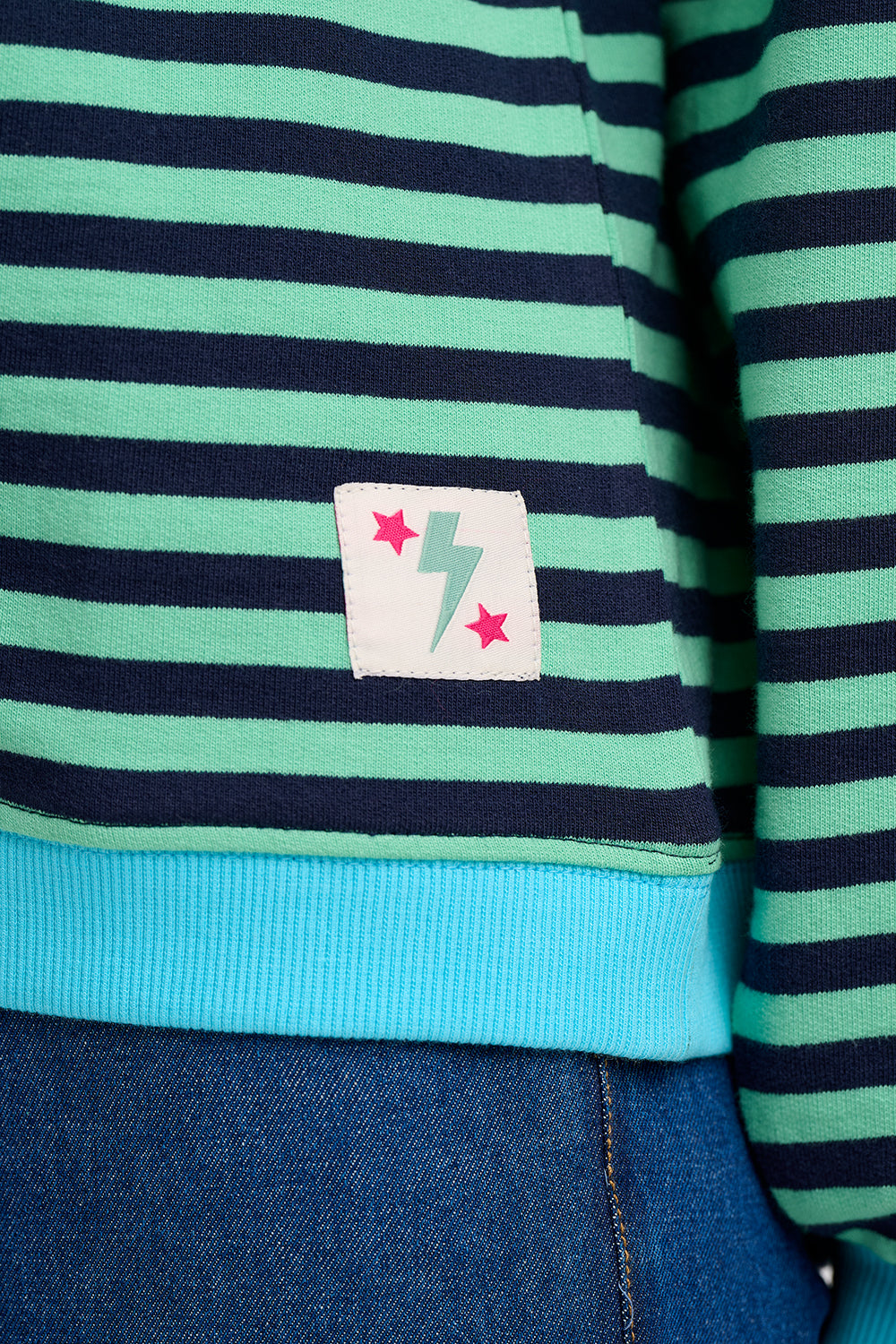 Suagrhill Brighton close-up of a striped shirt with a colorful label and blue trim.