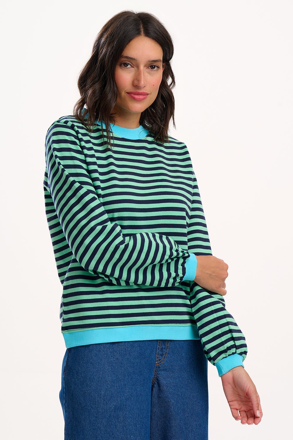 Suagrhill Brighton model wearing a green and black striped sweater with blue trim on a white background