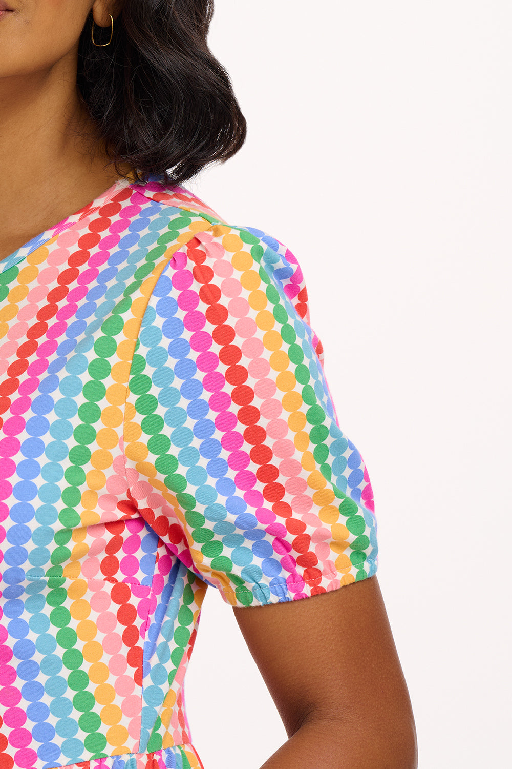 A model wearing a midi length tiered dress with a multicolored geometric pattern.