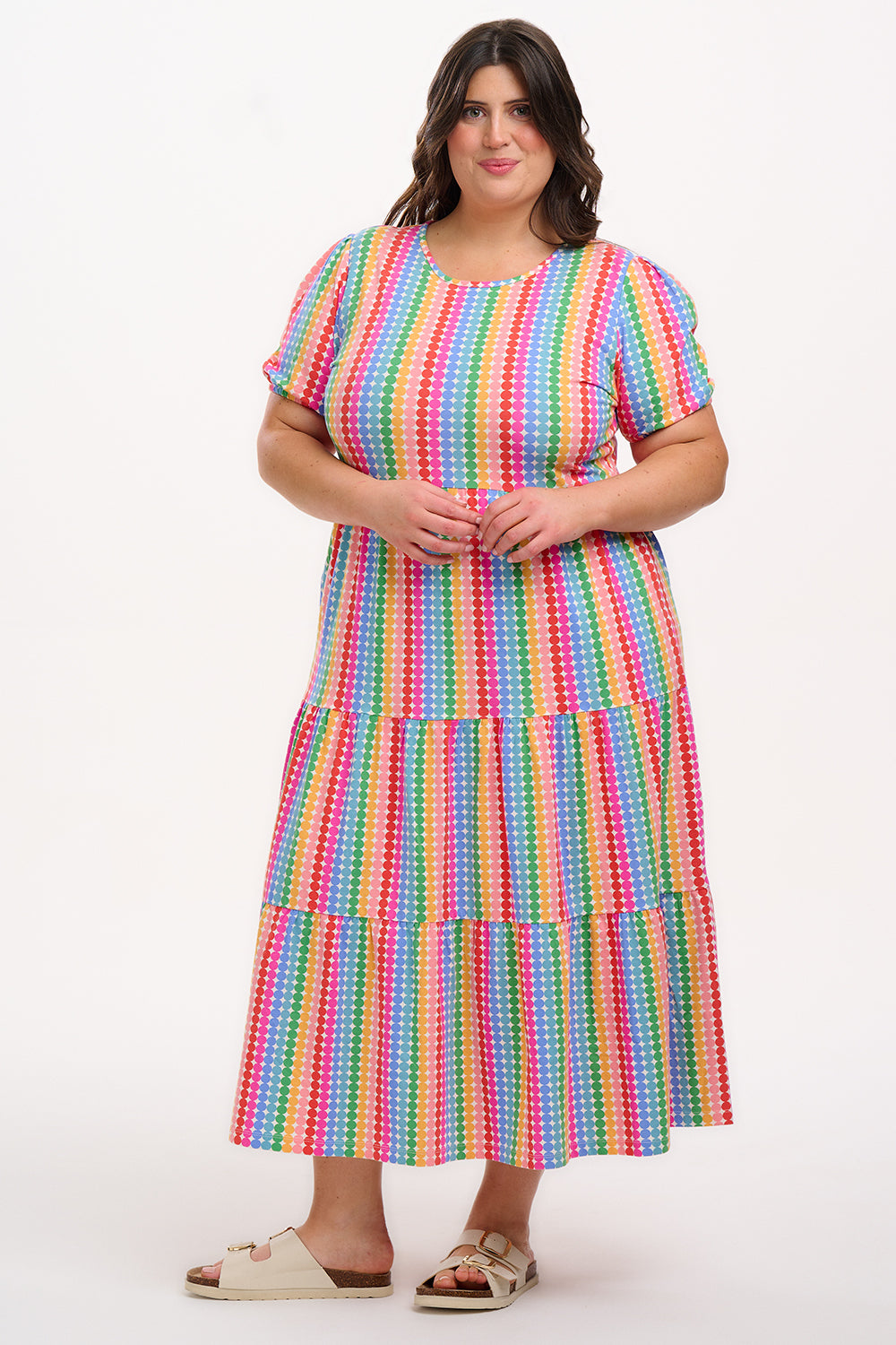 A model wearing a midi length tiered dress with a multicolored geometric pattern.
