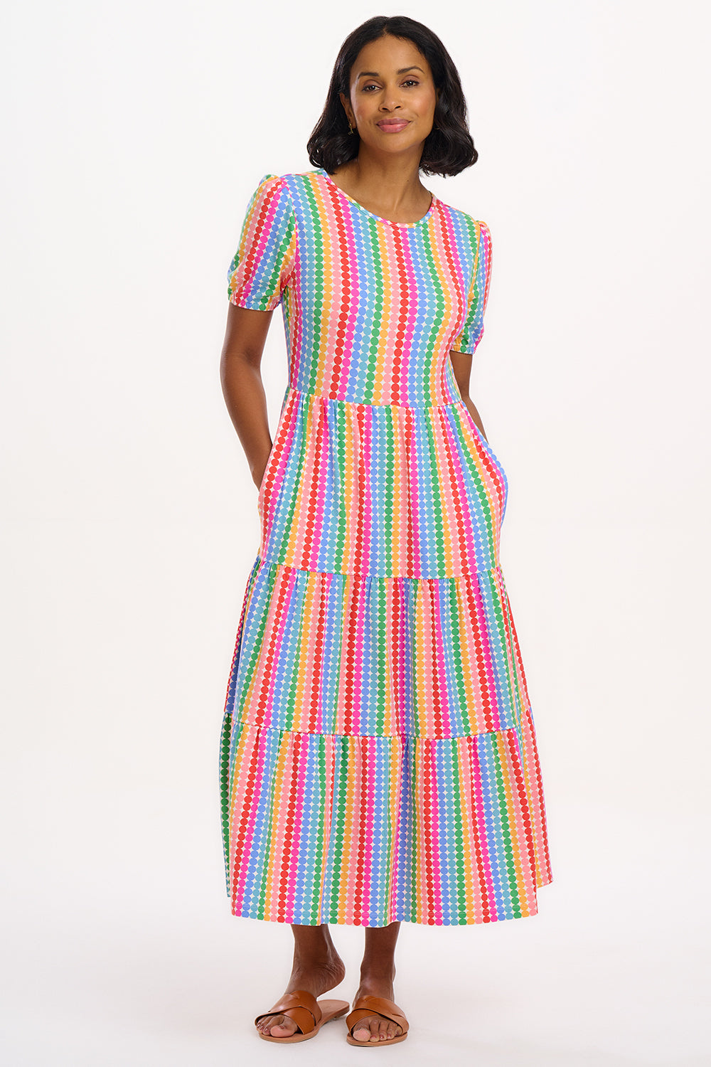 A model wearing a midi length tiered dress with a multicolored geometric pattern.