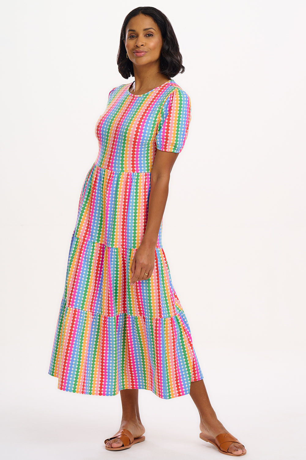A model wearing a midi length tiered dress with a multicolored geometric pattern.
