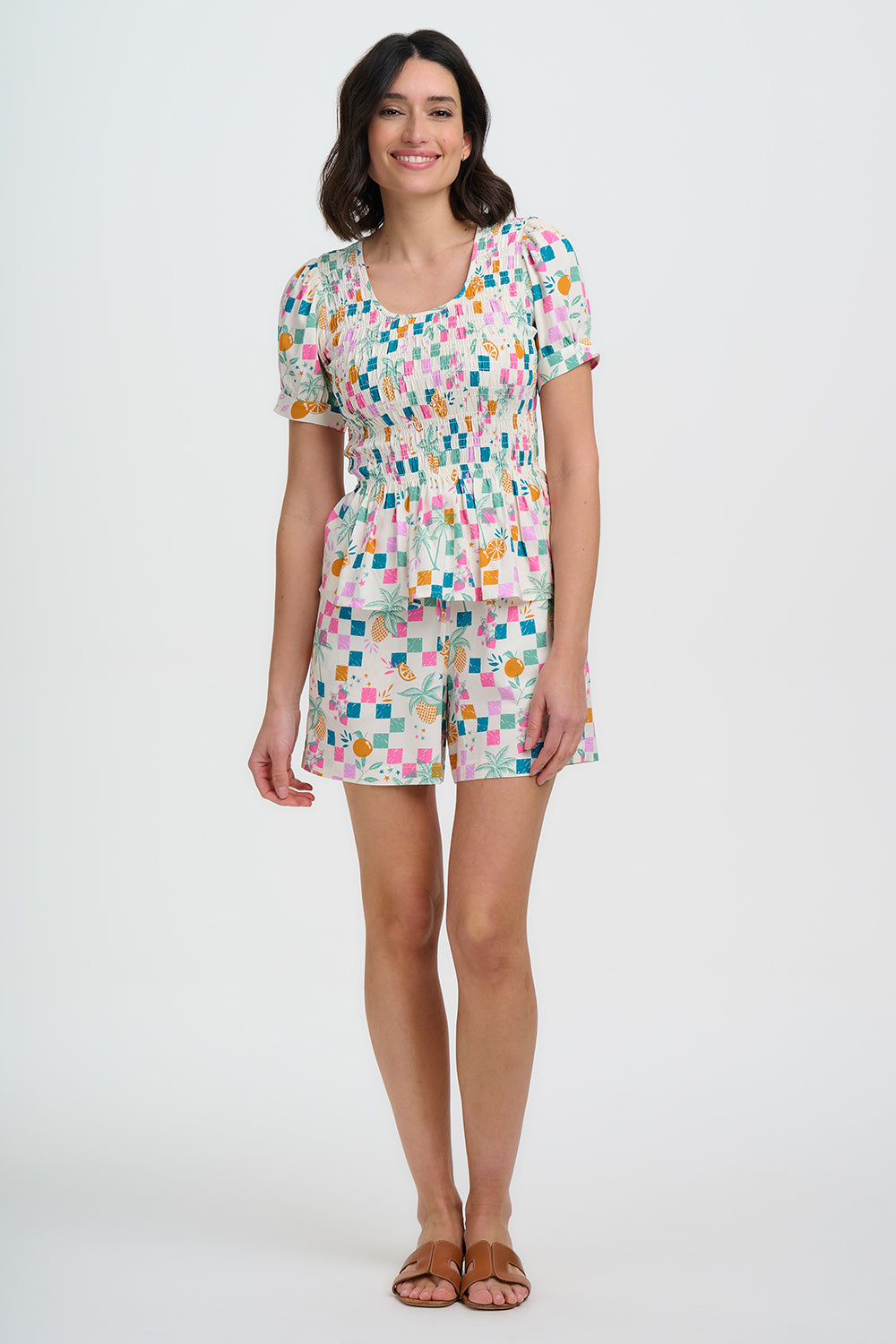 Woman wearing a colorful patterned dress on a white background