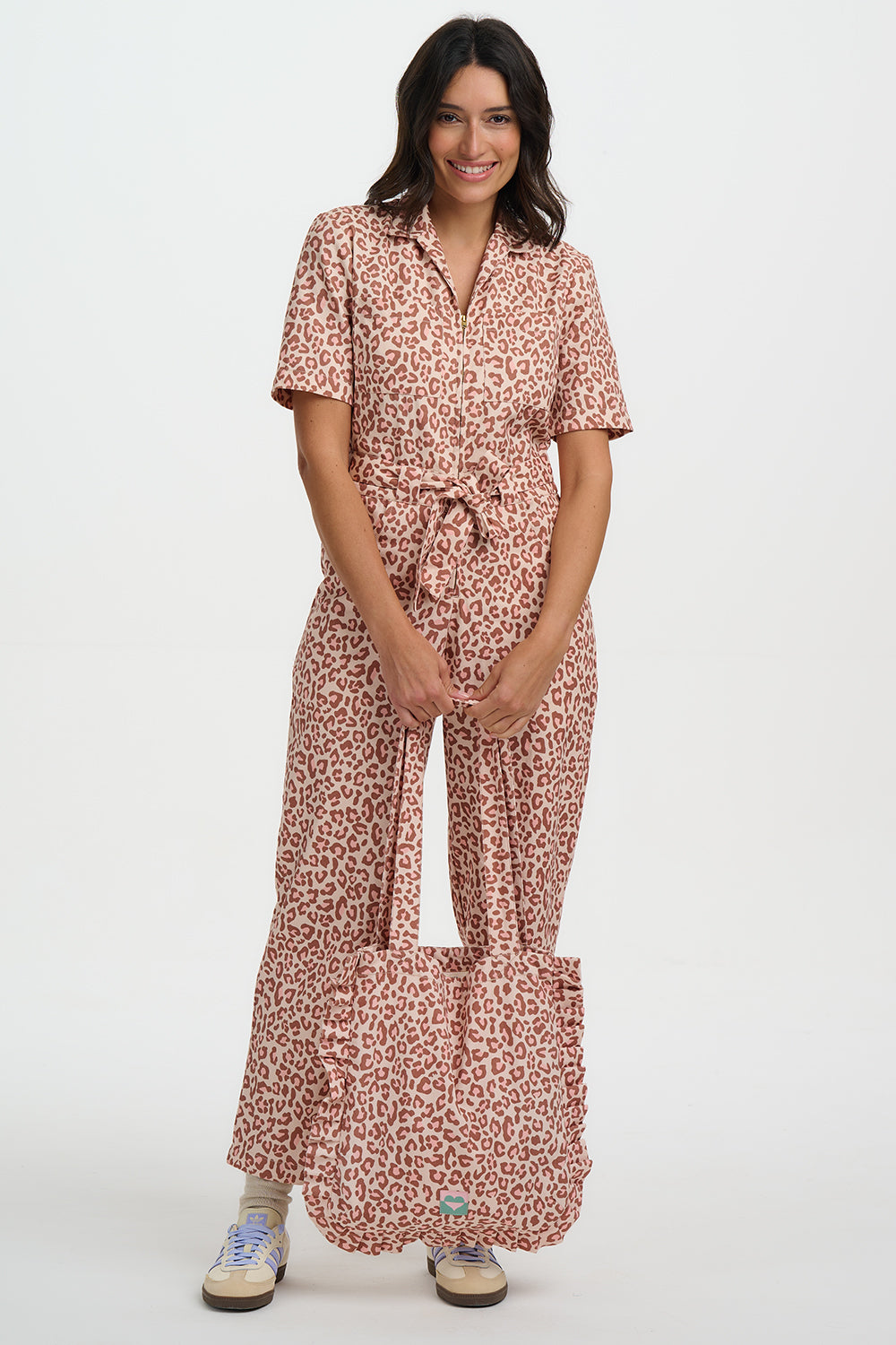 Woman wearing a patterned jumpsuit on a white background