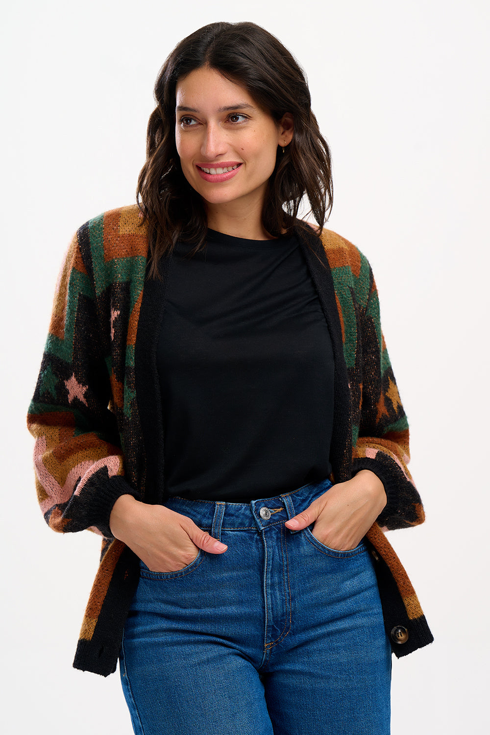 A woman wearing a multicolored geometric patterned cardigan with button front and long blouson sleeves.