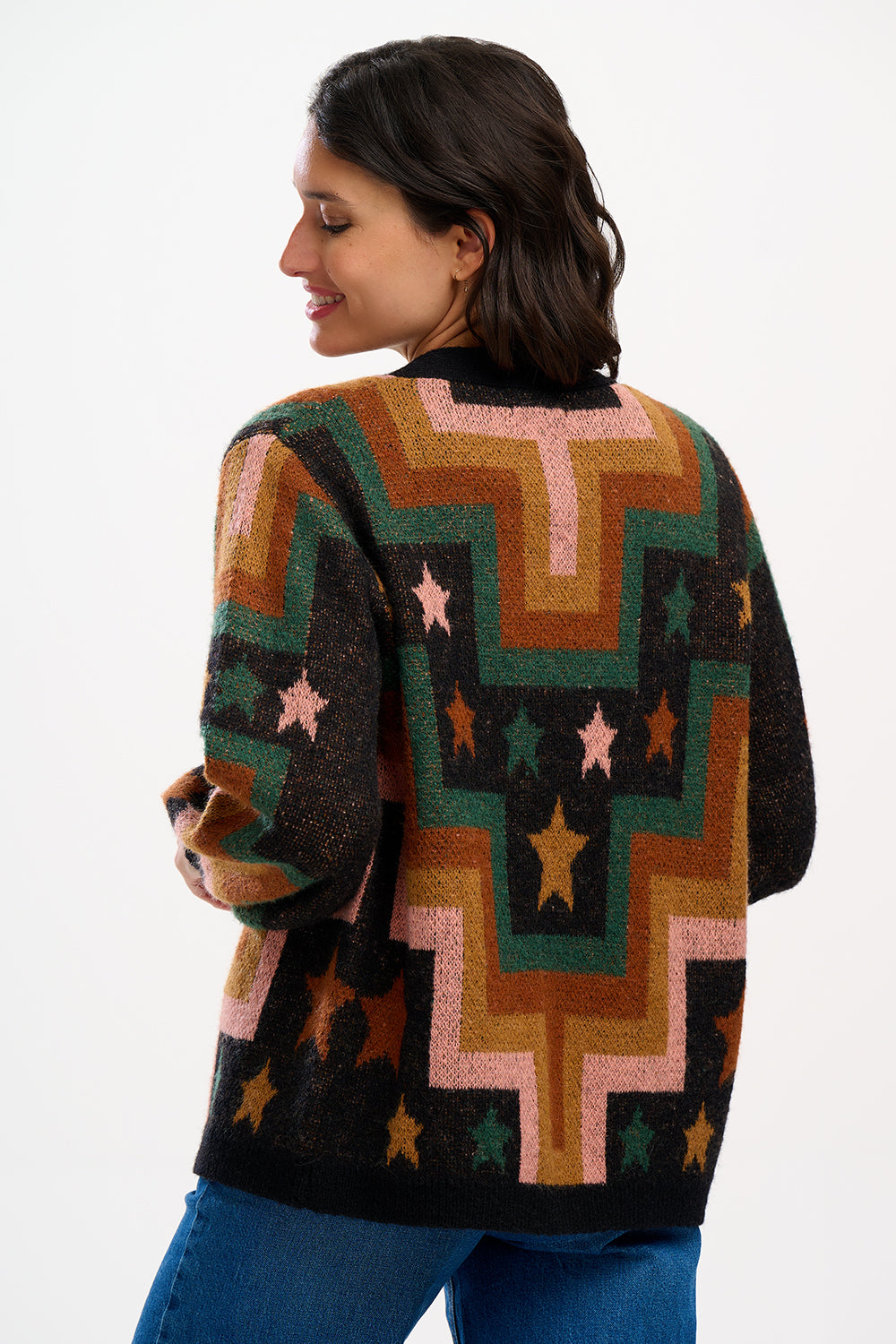 A woman wearing a multicolored geometric patterned cardigan with button front and long blouson sleeves.