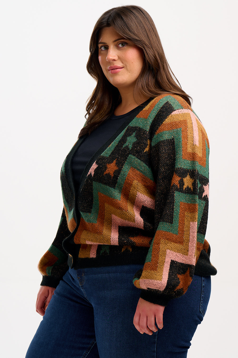 A woman wearing a multicolored geometric patterned cardigan with button front and long blouson sleeves.