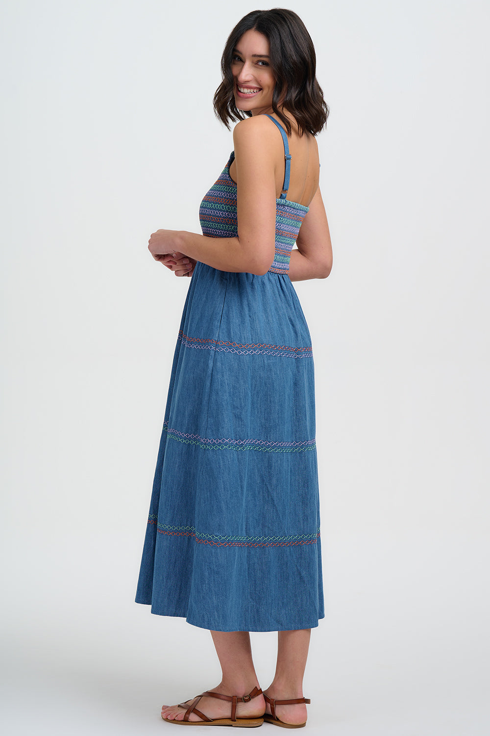 Woman wearing a blue denim dress with a white background