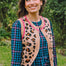 Sugarhill Brighton model wearing a leopard print cardigan over a plaid dress outdoors