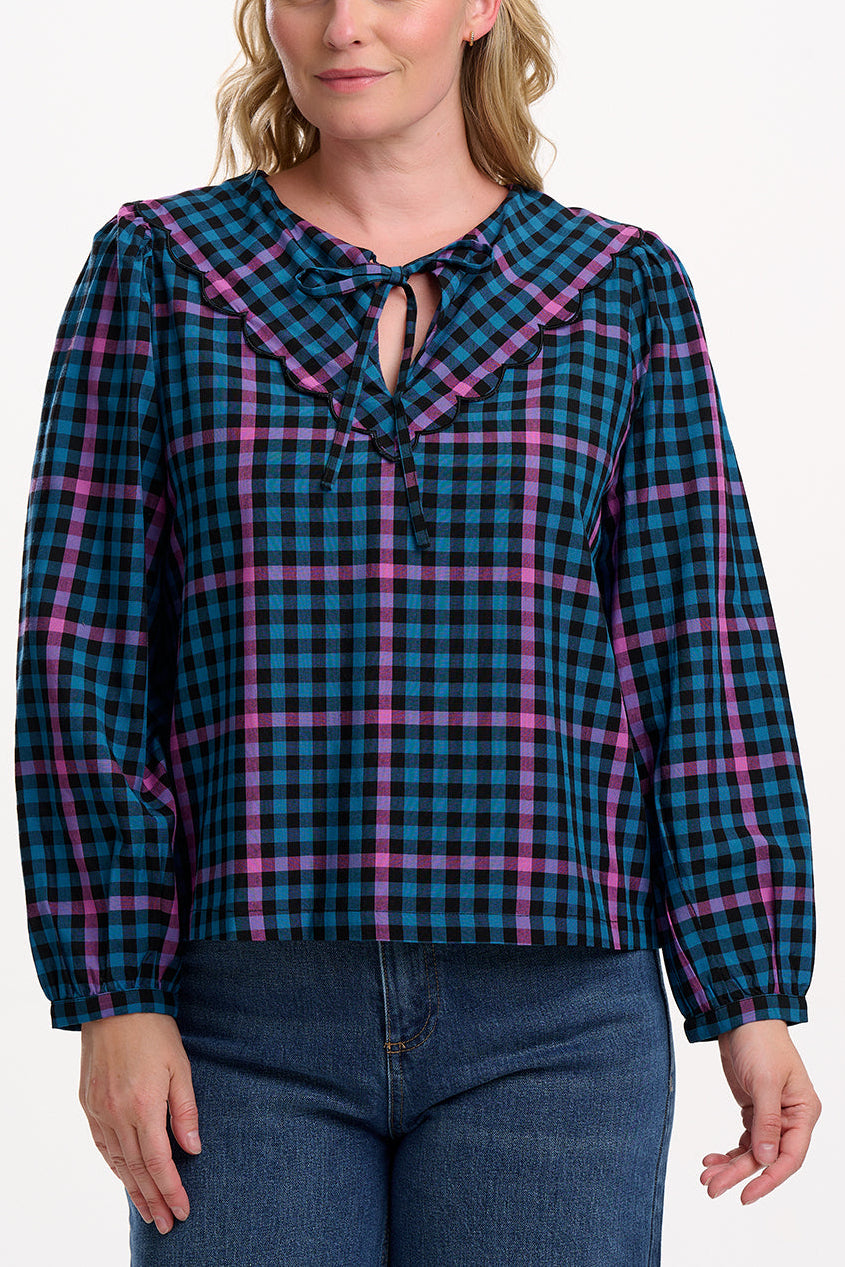 Sugarhill Brighton model wearing a blue and pink plaid shirt on a white background
