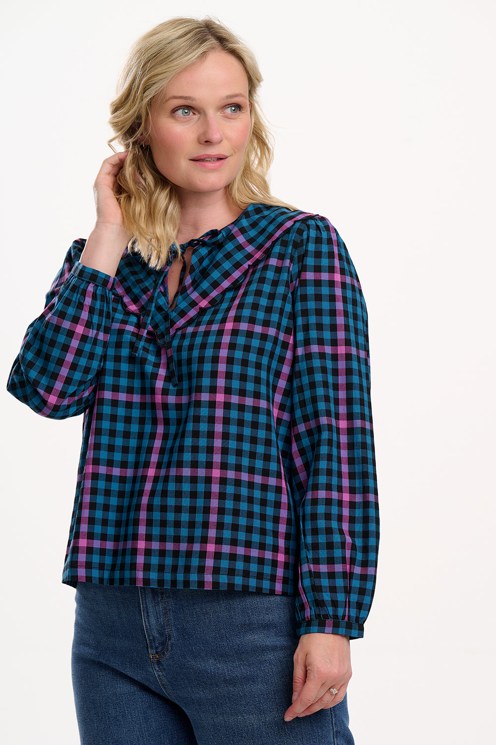 Sugarhill Brighton model wearing a blue and pink plaid shirt with a white background