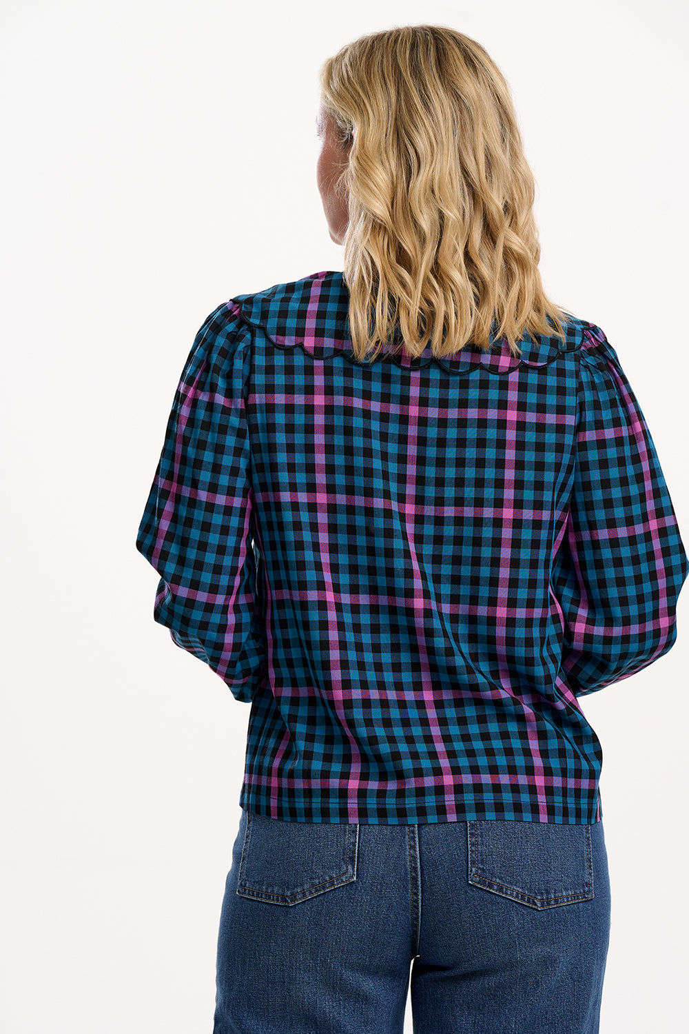 Sugarhill Brighton model wearing a blue and pink plaid shirt with puffed sleeves on a white background
