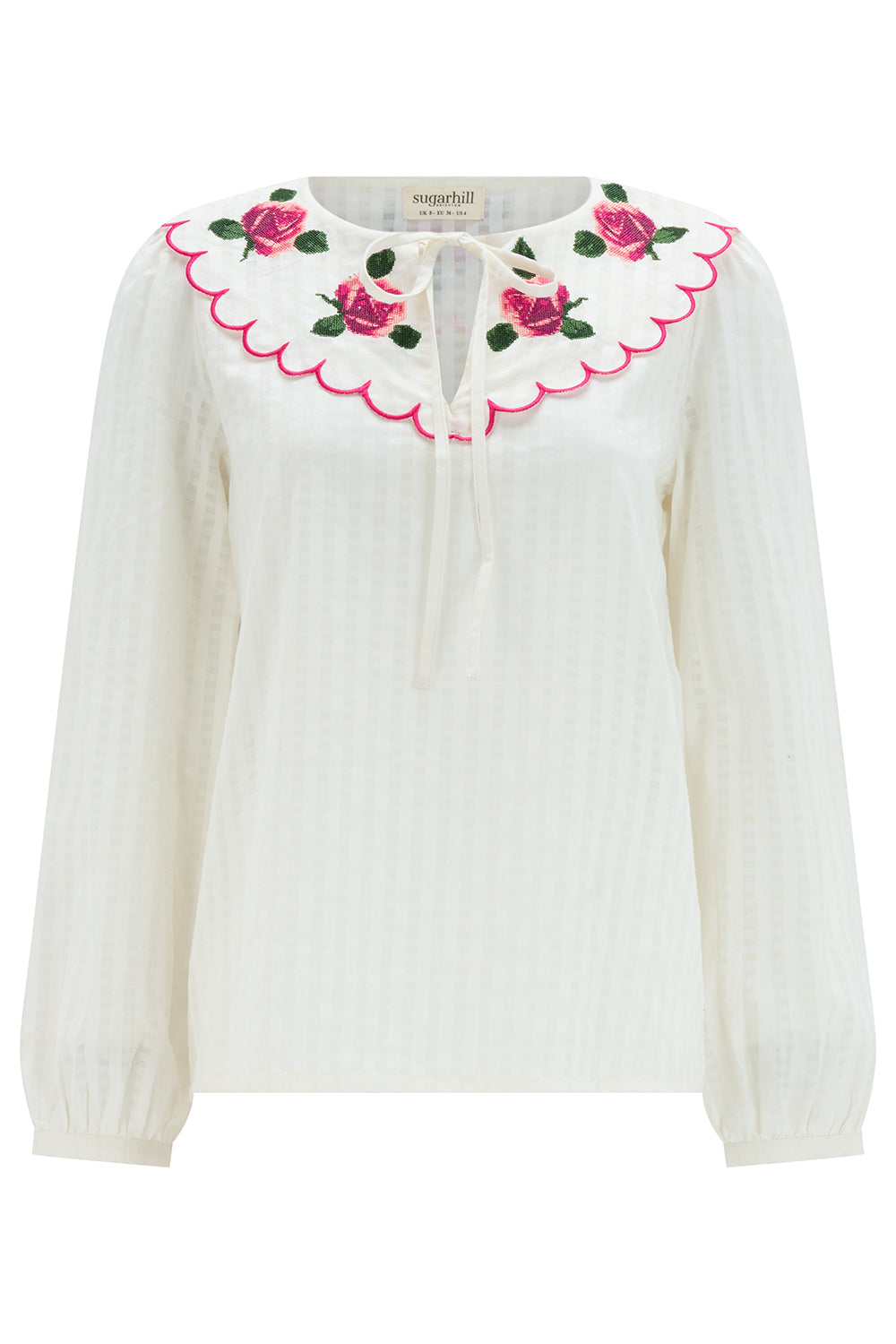 White blouse with pink floral embroidery on a white background