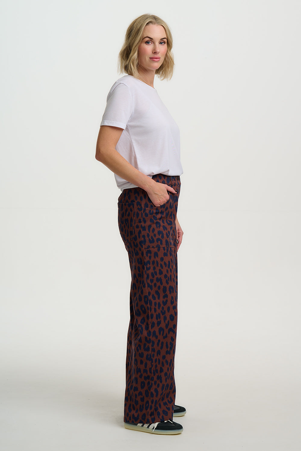 Woman wearing a white t-shirt and patterned pants on a white background