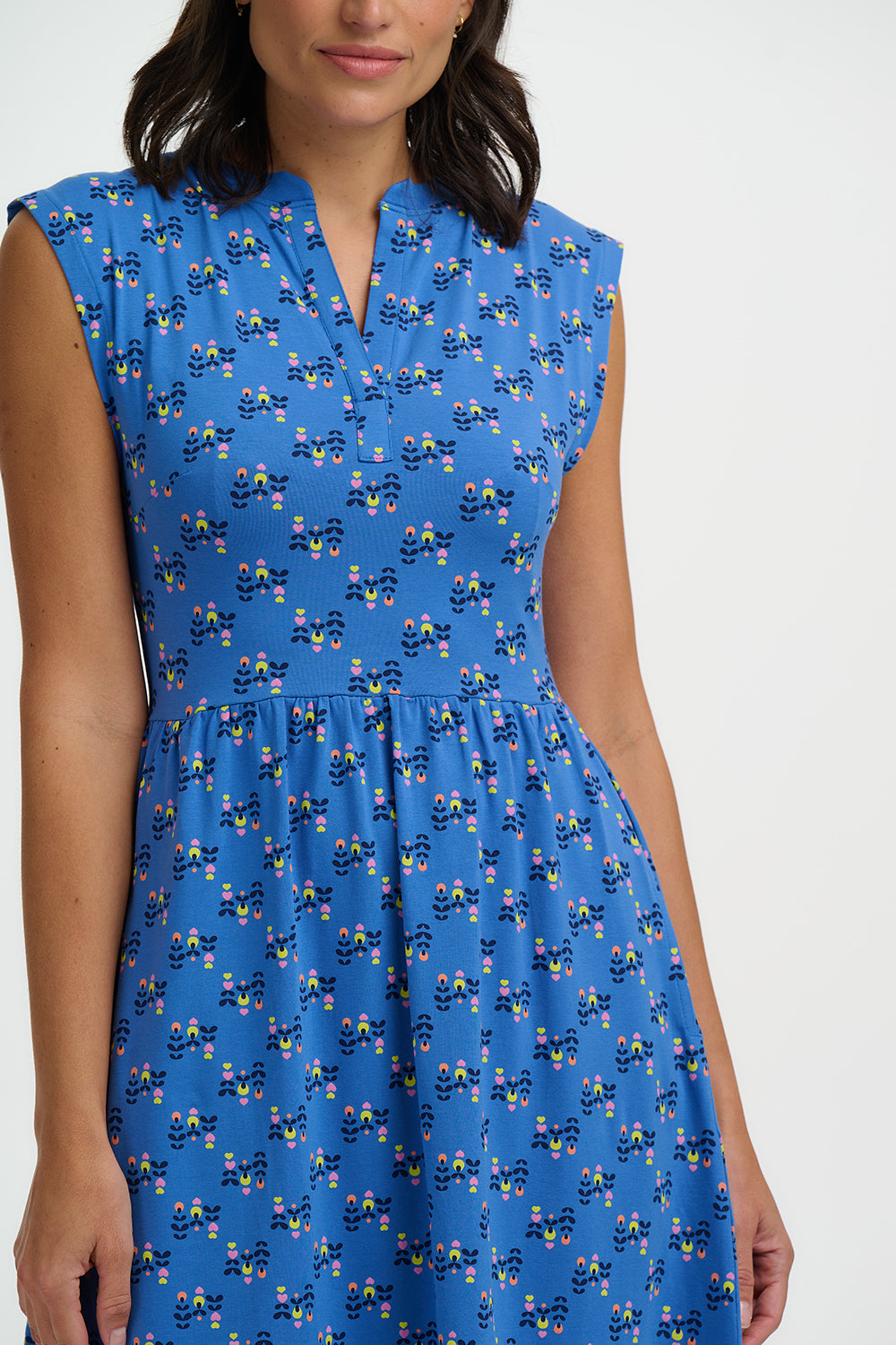 Woman wearing a blue dress with a pattern on a white background