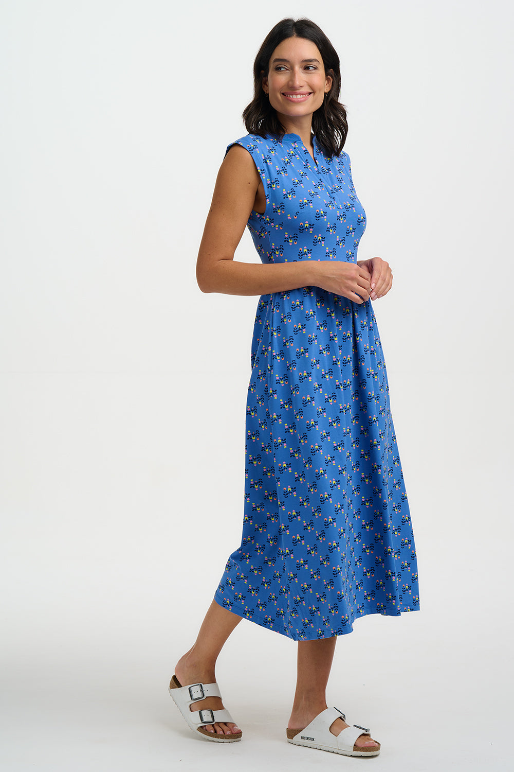 Woman wearing a blue dress with a pattern on a white background