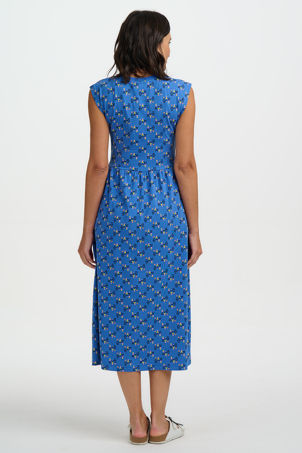 Woman wearing a blue dress with a pattern on a white background