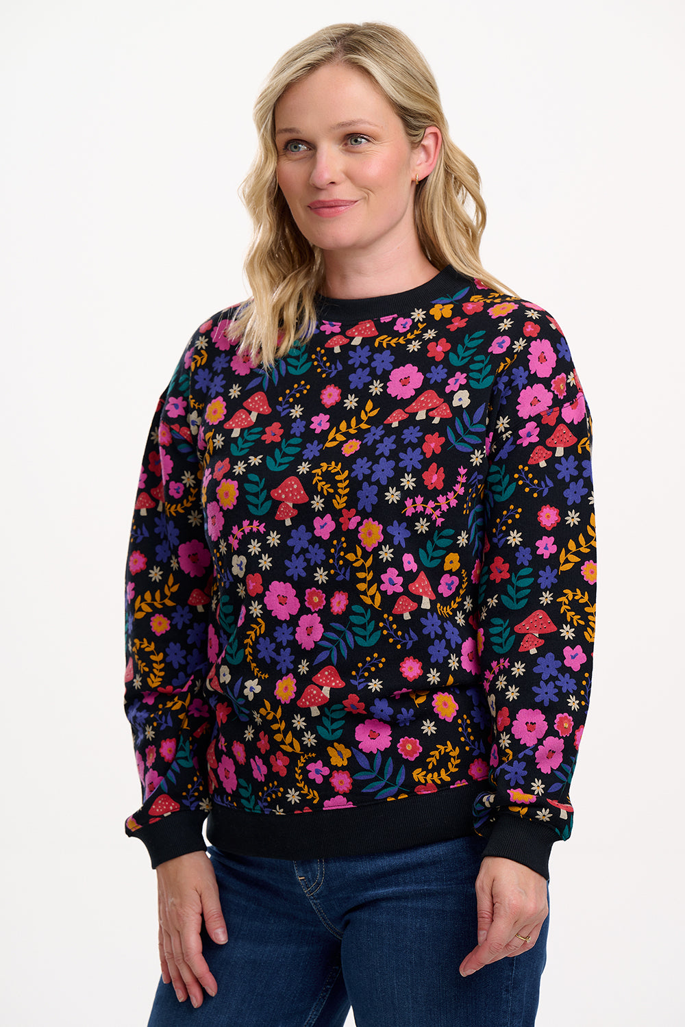 Woman wearing a colorful floral-patterned sweater on a white background