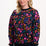 Woman wearing a colorful floral-patterned sweater on a white background