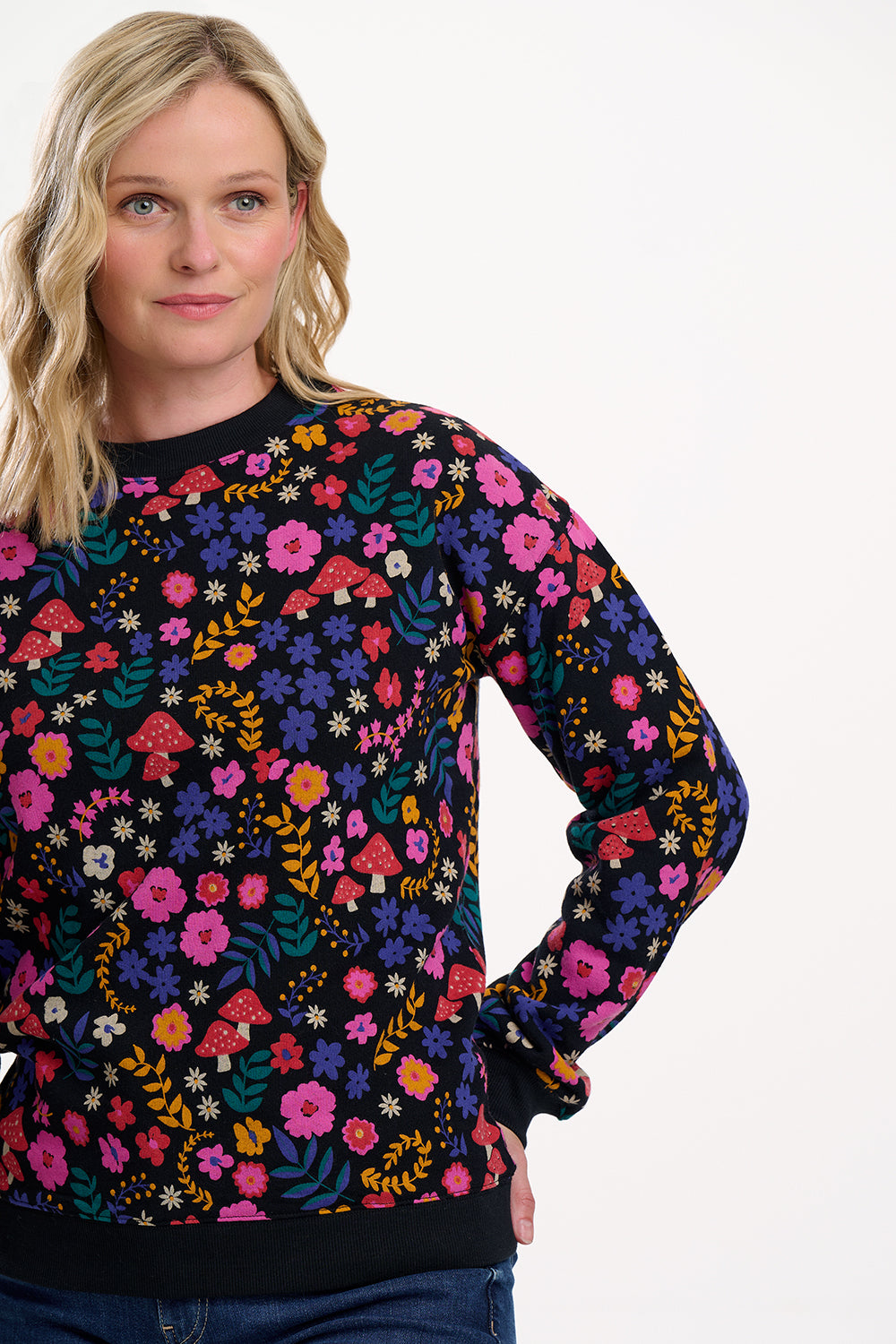 Woman wearing a colorful floral-patterned sweater on a white background