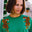 A woman wearing a green sweatshirt with embroidered tigers climbing the shoulders.